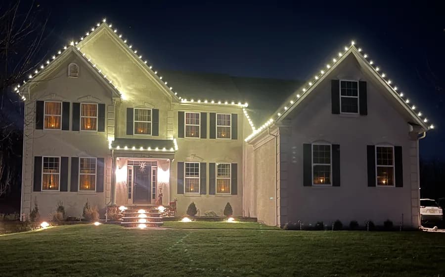 Warm white lighting following every eave and peak of a two-story home